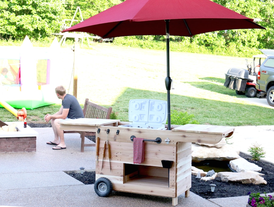 Outdoor party station mobile cart featuring storage for a large cooler, drawer that pulls out and doubles as a serving tray, pipe towel bar, and kiddie table! So COOL!