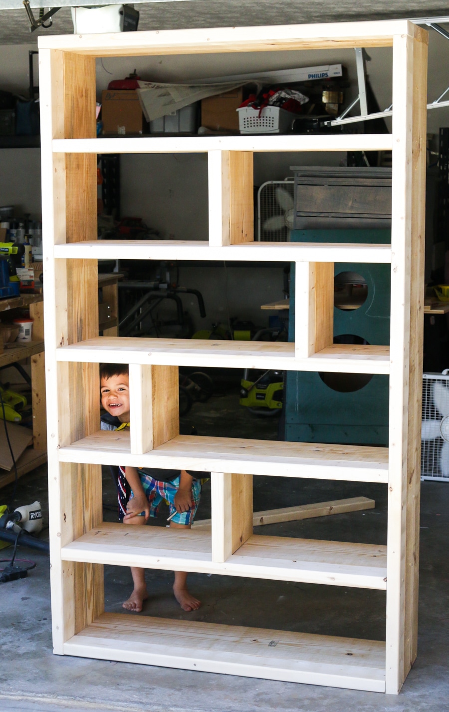 Tutorial and free plans on how to build a DIY rustic bookshelf with crates and reclaimed pallets