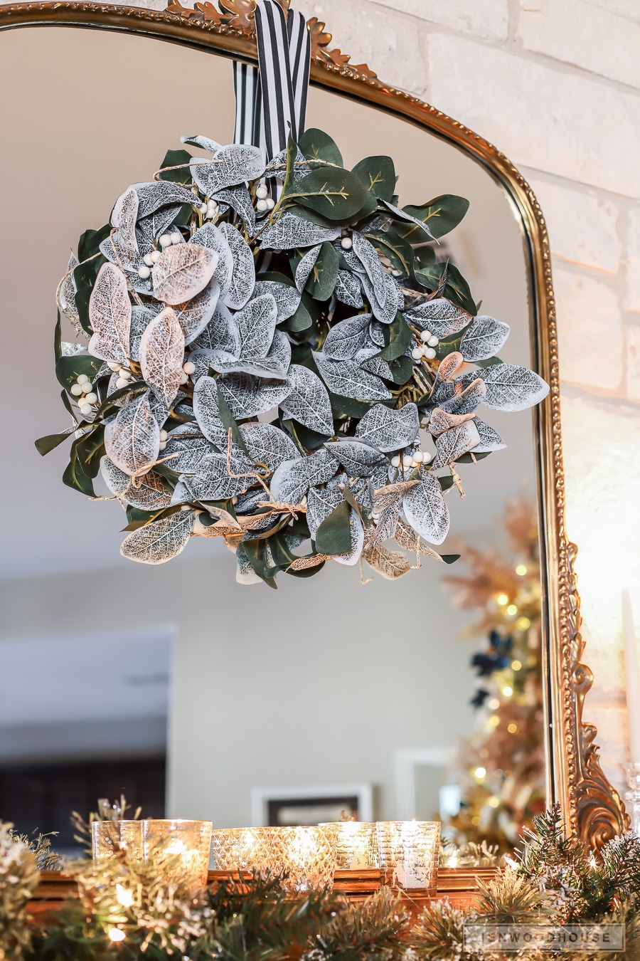 Magnolia wreath and antique mirror over mantel