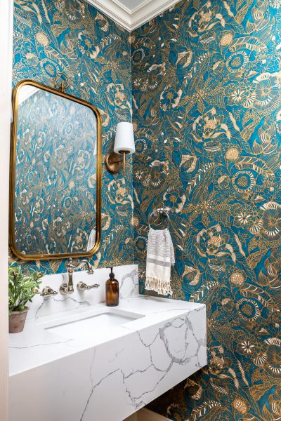 Gorgeous powder room renovation featuring a floating stone vanity and statement wallpaper