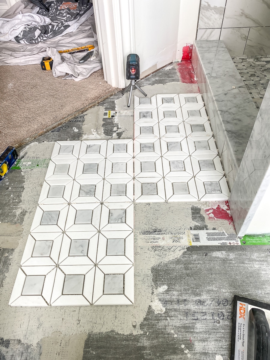 Tiling the bathroom floor with marble mosaic tiles