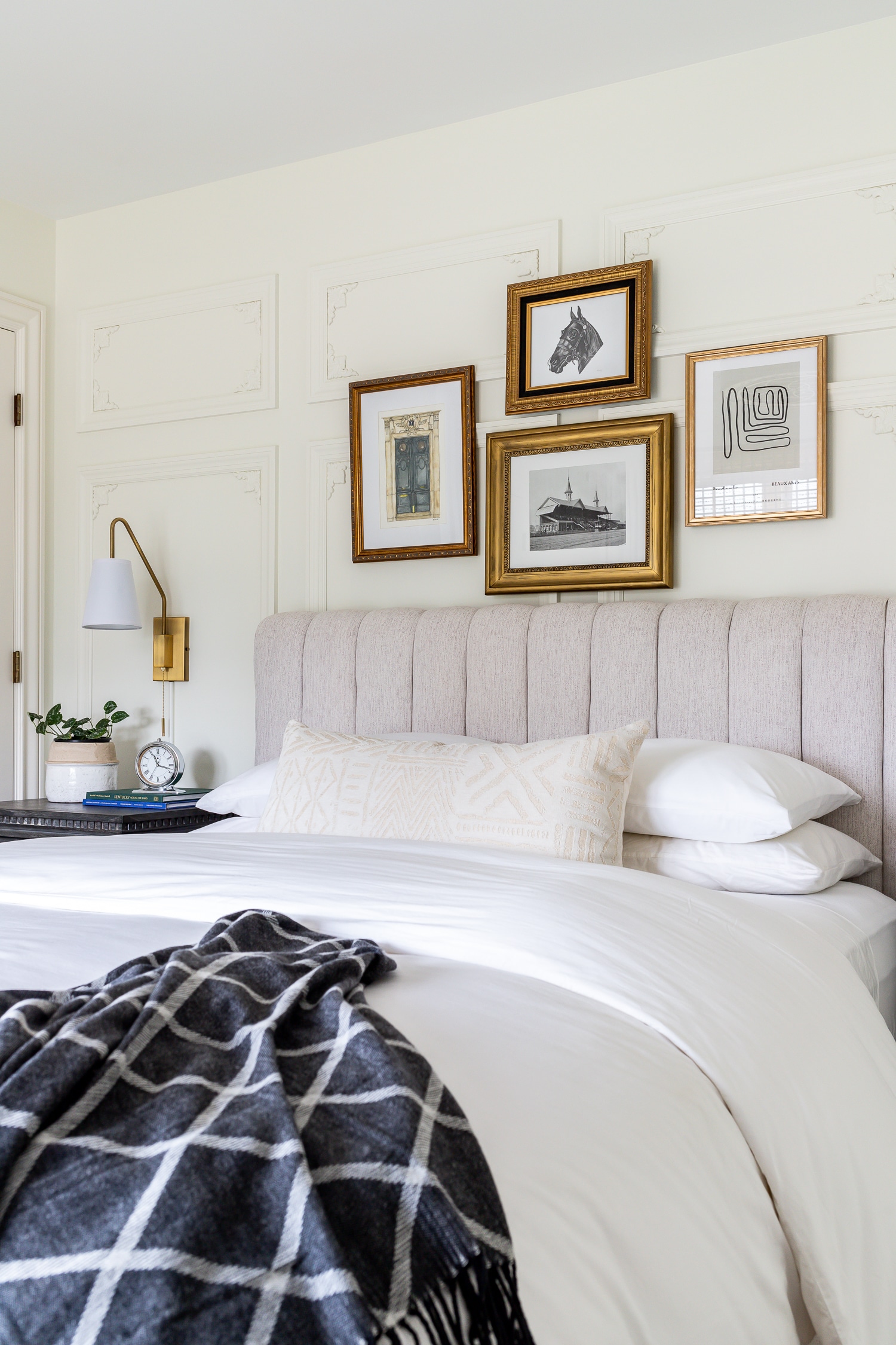 Art gallery with vintage frames above bed